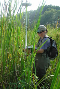 A student wears a GPS unit to inventory natural resources.